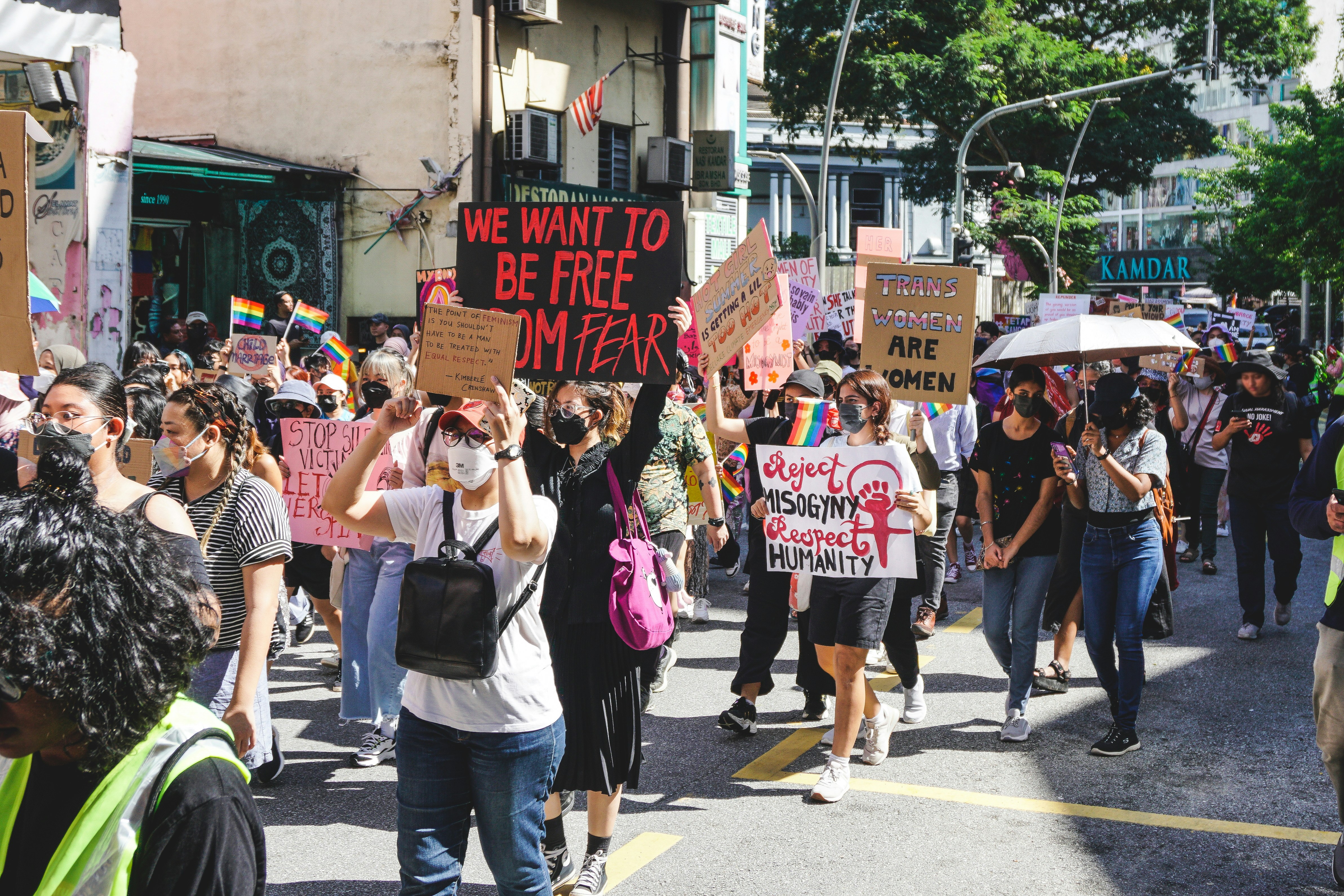 Demonstrators with women’s rights placards and Pride flags